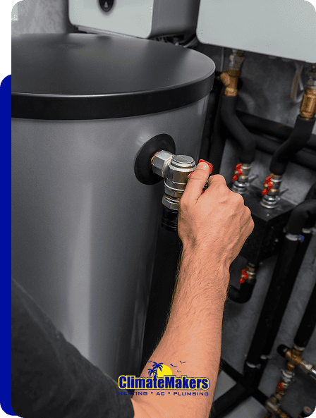 A person adjusts a valve on a water heater or boiler in a utility room; the climatemakers Heating AC Plumbing logo appears at the bottom of the image.